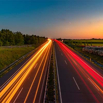 Dual-lane highway at sunset symbolizing efficient, cost-effective asphalt solutions for smaller repair jobs