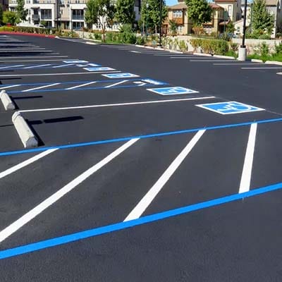 Freshly paved parking lot with painted lines and accessible parking bays