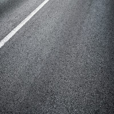 Close-up view of freshly laid asphalt road surface with white line  ideal example of road asphalt surfacing