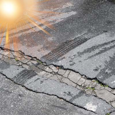 Cracked asphalt surface caused by UV radiation and prolonged sun exposure