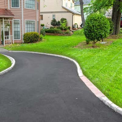 Newly paved residential asphalt driveway with clean edging and smooth finish