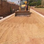 Grader preparing the foundation of a driveway or private road with compacted earth and edging in place